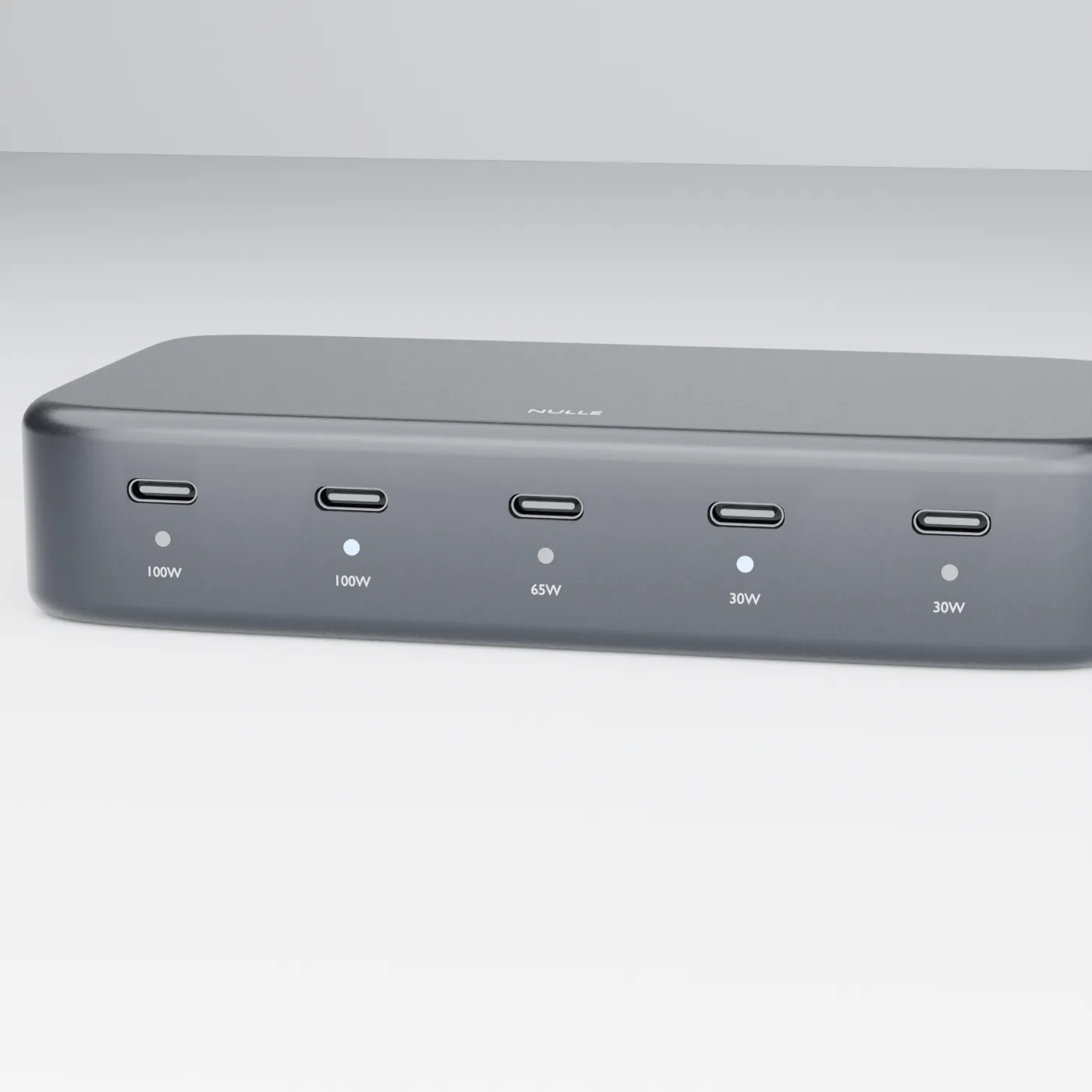Low-key three-quarter study of the NULLE USB-C hub showing its dark enclosure, five ports, and status indicators.