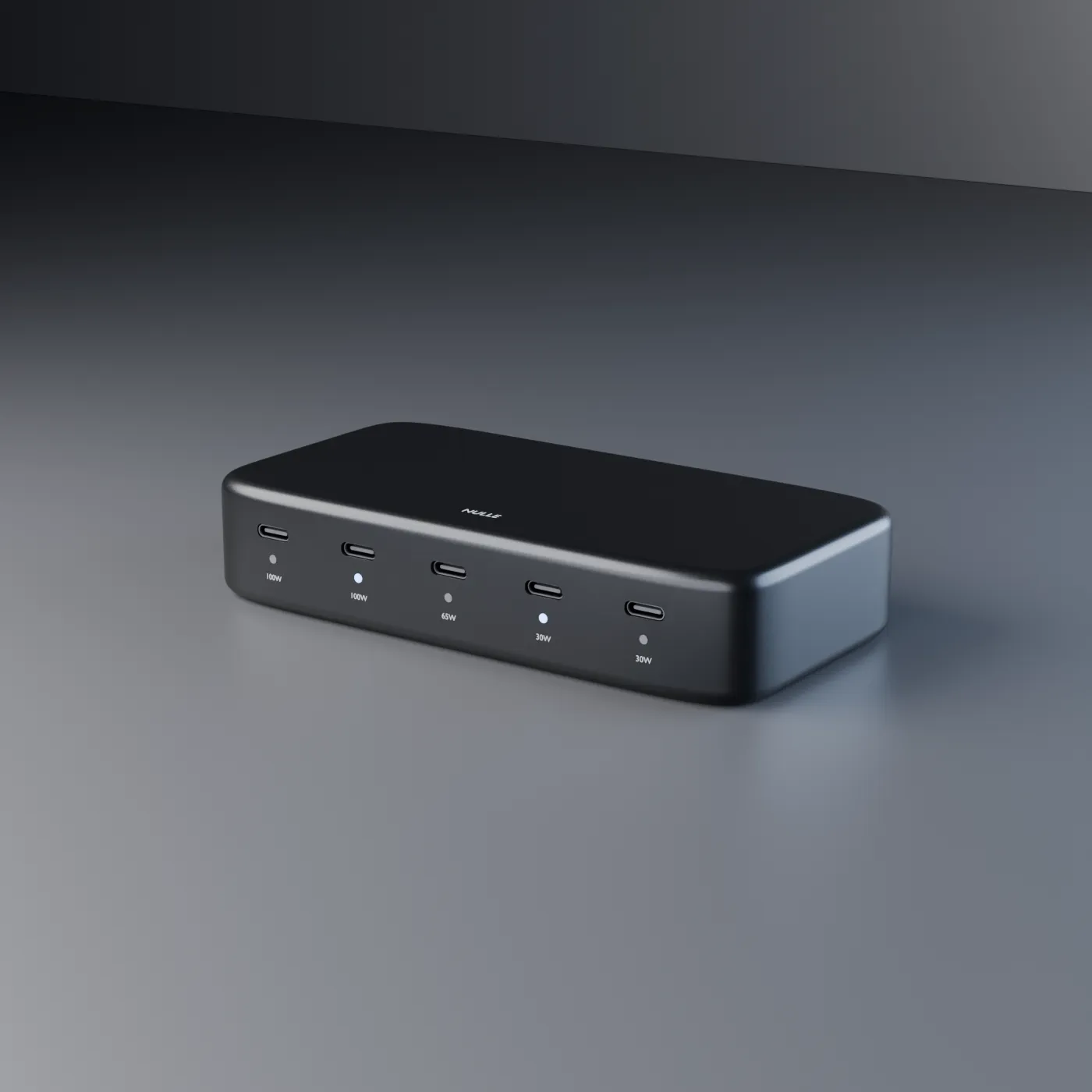 Graphite NULLE desktop USB-C power hub shown in three-quarter view with five front ports and labeled power outputs.